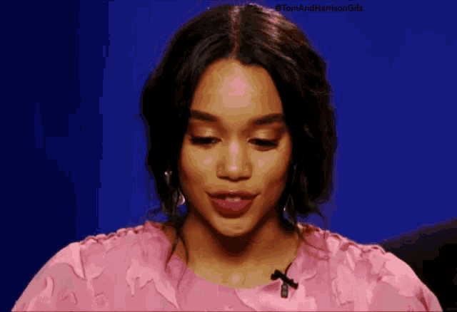 a woman in a pink dress is looking down at something