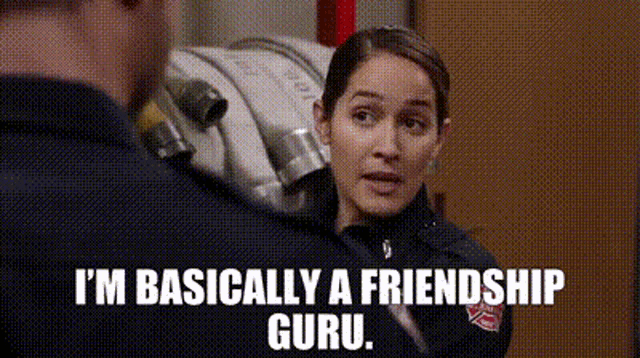 a woman in a fireman 's uniform is talking to a man in a fire station .