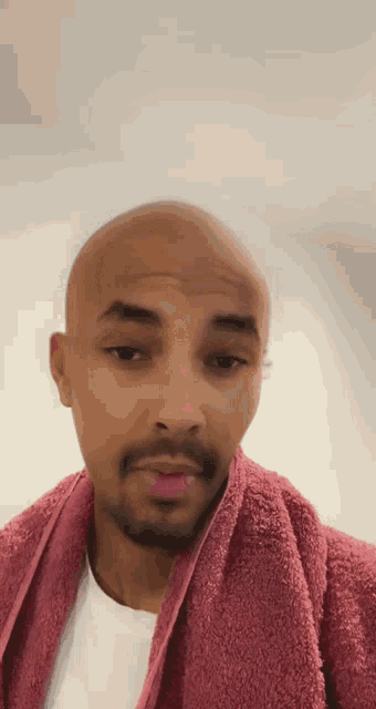 a man with a pink towel around his neck