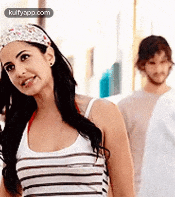 a woman wearing a headband is standing next to a man in a white shirt .