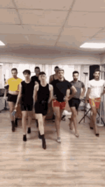 a group of men are dancing in a room