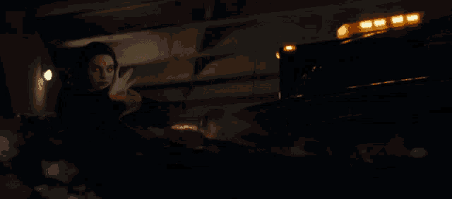 a woman in a black dress is standing in front of a car with a yellow light on the top