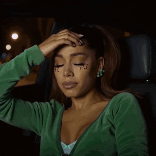 a woman in a green sweater is crying
