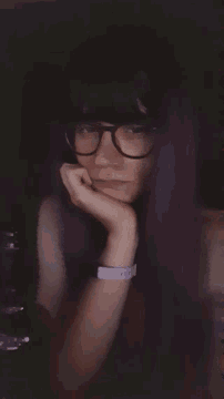 a woman wearing glasses and a wristband that says i love you