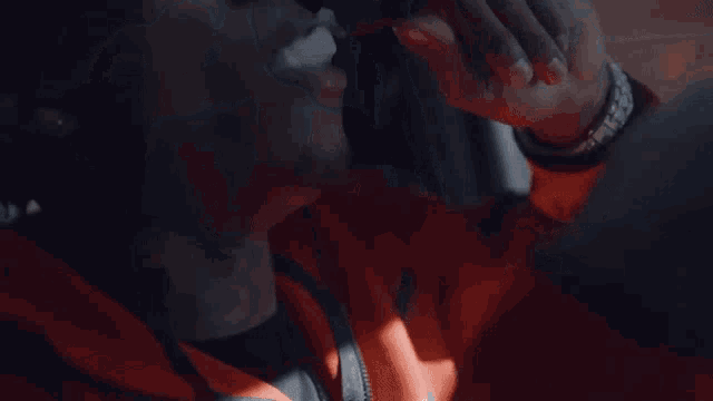 a close up of a person smoking a cigarette with smoke coming out of their mouth .