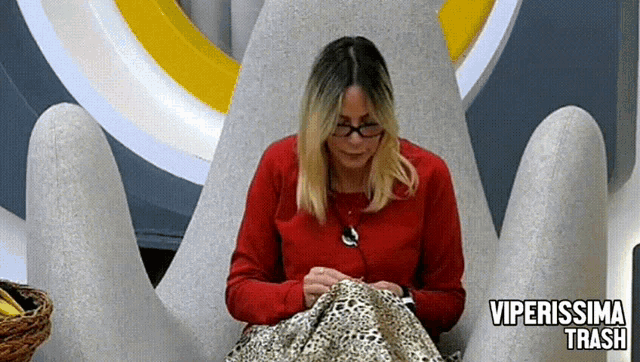 a woman in a red sweater is sitting in a chair with the words viperissima trash on the bottom
