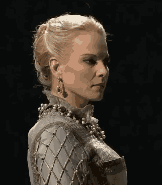 a woman with blonde hair wearing pearls and earrings