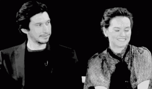 a black and white photo of a man and a woman standing next to each other .