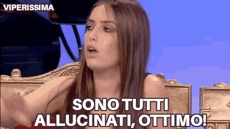 a woman is sitting in a chair and saying sono tutti allucinati ottimo !