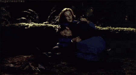 a man and woman are hugging each other in the dark .