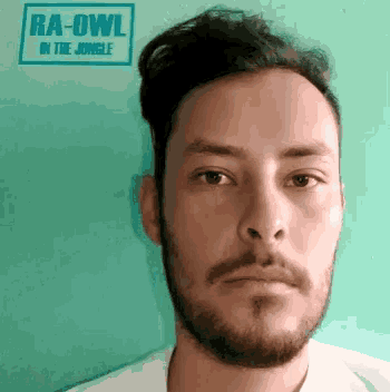 a man with a beard and a sign that says ra-owl in the jungle on it