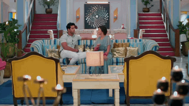 a man and woman sitting on a couch in a living room