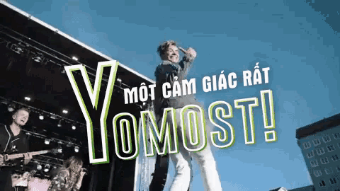 a group of people on a stage with yomost written on the top