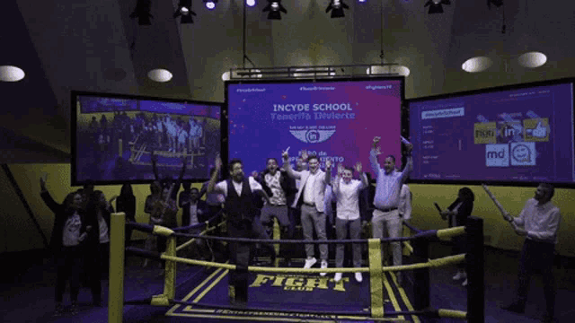 a group of people are standing in a boxing ring with a sign that says incydf school
