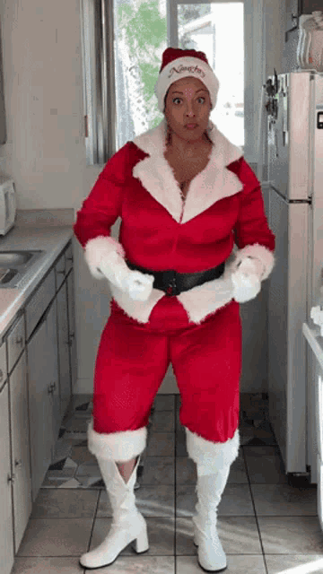 a woman in a santa costume is standing in front of a white refrigerator