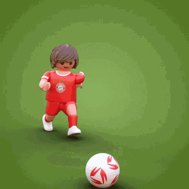 a toy soccer player with a red shirt that says bayern on it