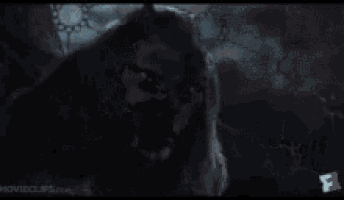 a person is holding a dead animal in their arms in a snowy forest .