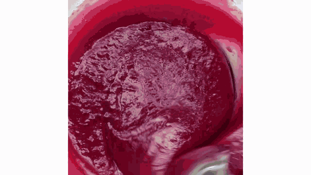 a close up of a red liquid in a container