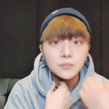 a close up of a person wearing a blue hat and a hoodie