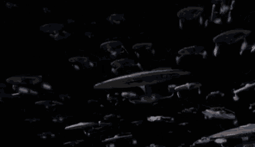 a group of space ships are flying in a dark space .