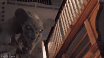 a statue of a monster is standing on a set of stairs in a house .