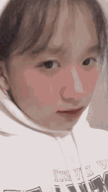 a close up of a girl wearing a white hoodie