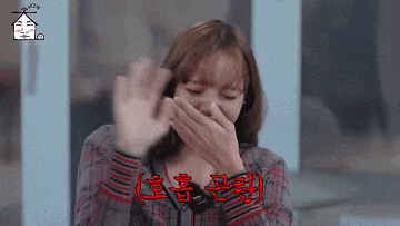 a woman is covering her mouth with her hand while laughing .