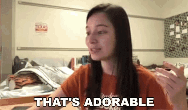 a girl says that 's adorable in front of a texas sign