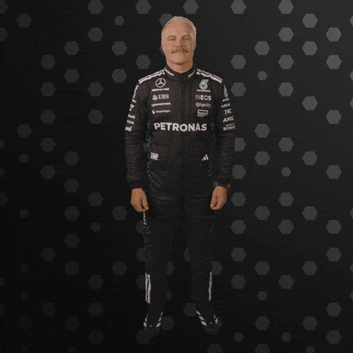 a man with a mustache is wearing a petronas racing suit