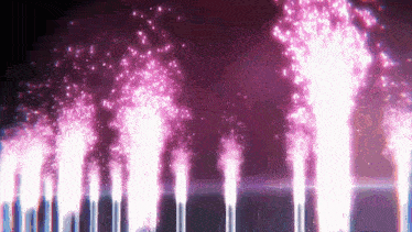 a row of purple fireworks are displayed in the night sky