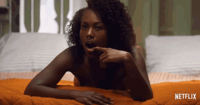 a naked woman is laying on a bed with a netflix logo in the background