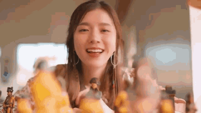 a woman is sitting at a table with a bunch of figurines in her hands .