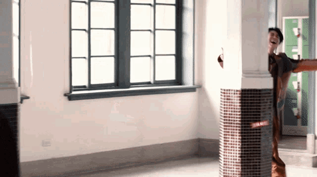a man is standing in an empty room with a window