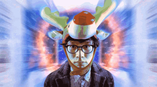 a man wearing a reindeer hat and glasses looks at the camera
