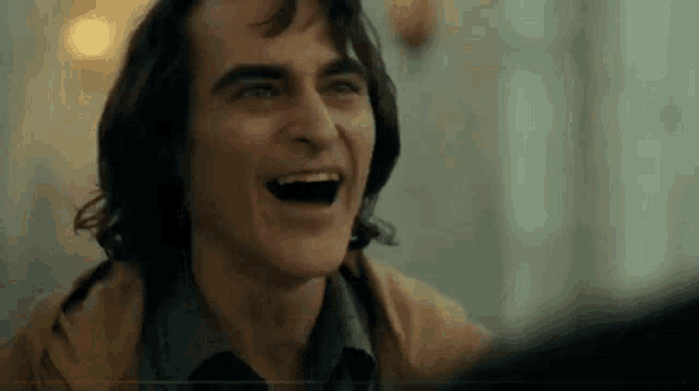 a close up of a man laughing with his mouth open in a movie .