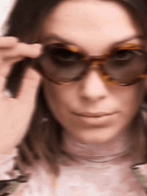 a woman wearing sunglasses looks at the camera