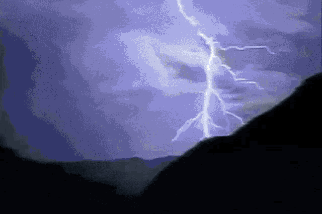 a lightning bolt strikes a mountain in a purple sky