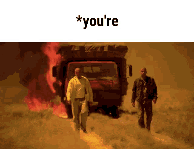 two men walking in front of a truck that is on fire .