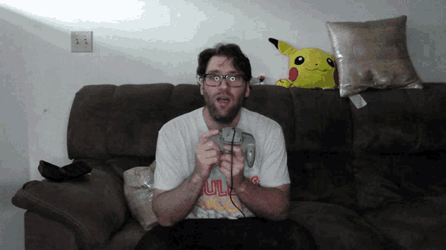 a man sitting on a couch playing a video game with a shirt that says ulm