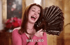a woman is laughing while holding a fan in her hand .