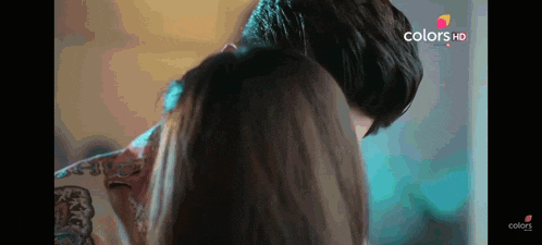 a man with a tattoo on his back is kissing a woman
