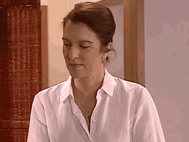 a woman wearing a white shirt and a necklace