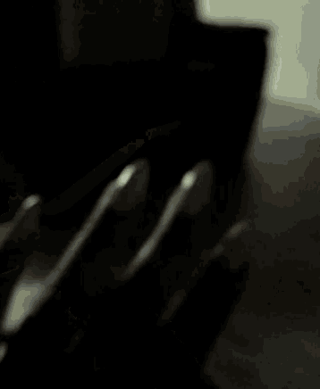 a dark living room with a black couch and chairs