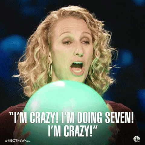 a woman holding a green balloon that says " i 'm crazy i 'm doing seven