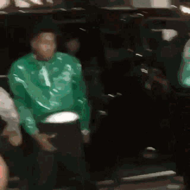 a blurry picture of a man wearing a green hoodie with the number 13 on it