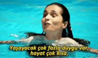 a woman is swimming in a pool with a caption in a foreign language