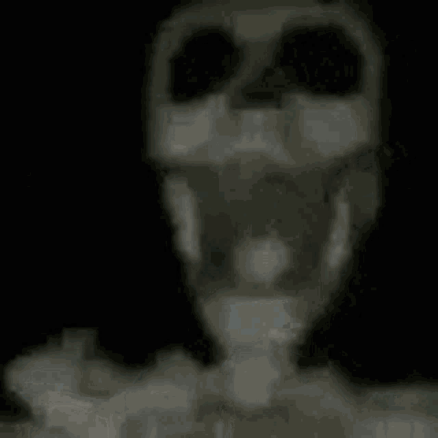 a skeleton is standing in the dark with its mouth open and a long antenna coming out of its head .