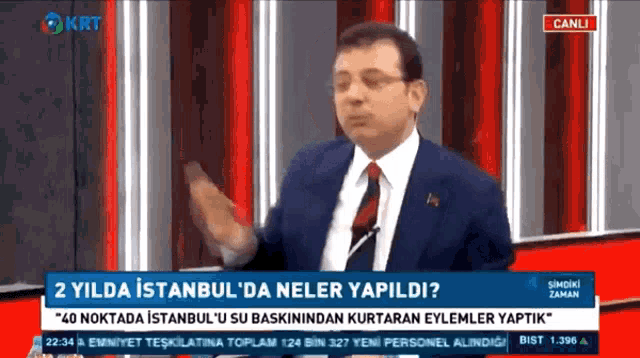 a man in a suit and tie is speaking on a tv show