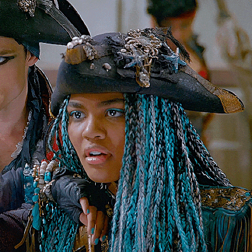 a woman with blue braids is wearing a hat