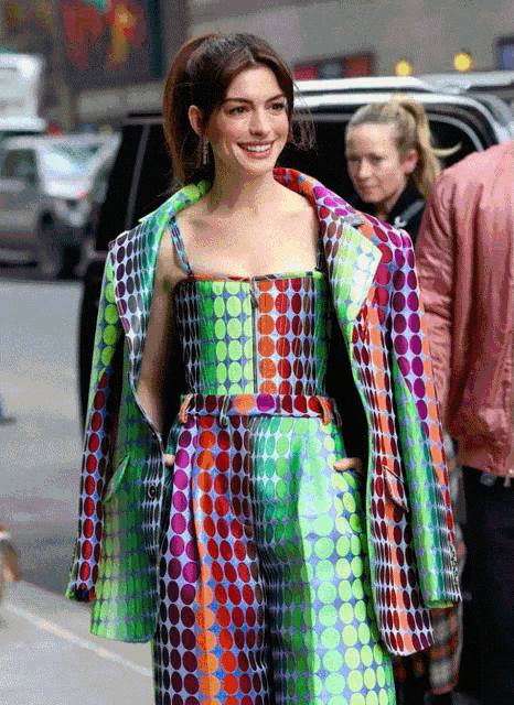 a woman in a colorful polka dot dress and jacket